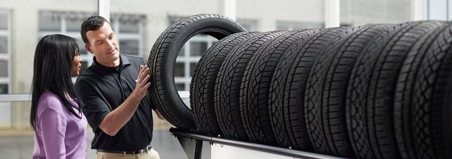 Subaru service representative showing customer a tire. | Bob Johnson Subaru Watertown in Watertown NY